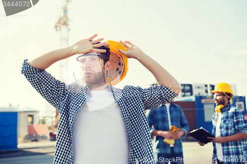 Image of group of builders in hardhats outdoors