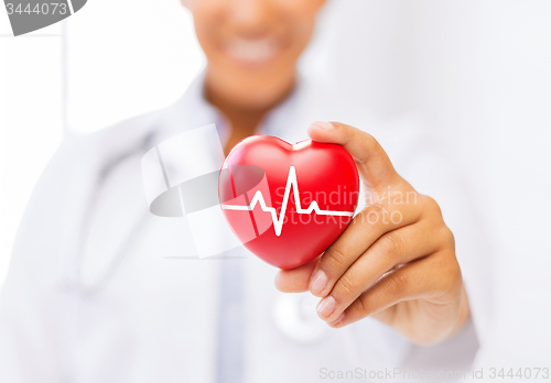 Image of female doctor holding red heart with ecg line