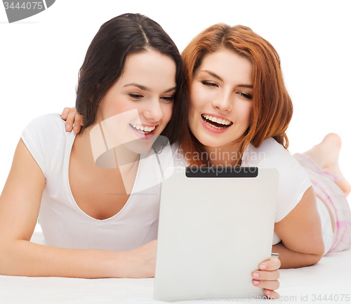 Image of two smiling teenage girsl with tablet pc computer