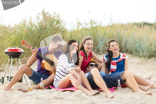 Image of group of happy friends having fun on beach