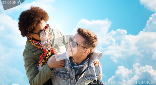 Image of happy teenage couple in shades having fun outdoors