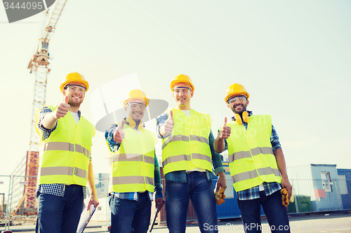 Image of group of smiling builders with tablet pc outdoors