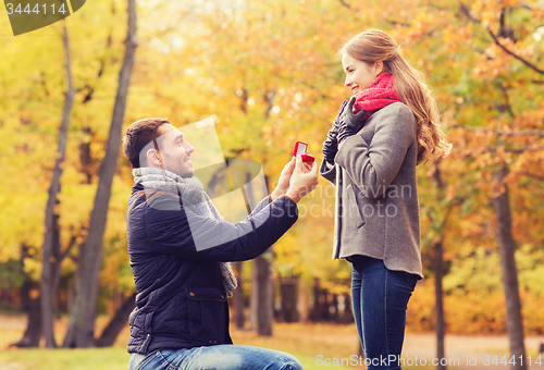 Image of smiling couple with engagement ring in gift box