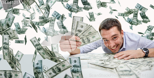 Image of happy businessman with heap of money