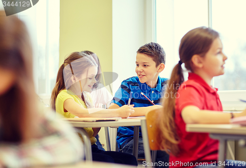 Image of group of school kids writing test in classroom