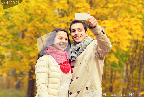 Image of smiling couple hugging in autumn park