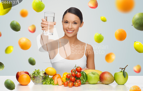 Image of happy woman with healthy food showing water glass