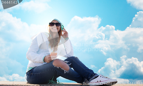 Image of happy young woman with smartphone and headphones