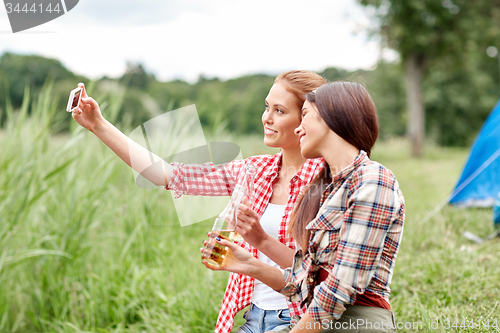 Image of happy women taking selfie by smartphone at camping