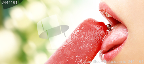 Image of woman with pierced tongue licking fruit ice cream