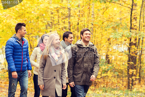 Image of group of smiling men and women in autumn park