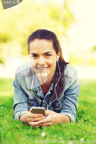Image of smiling young girl with smartphone and earphones