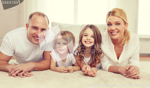 Image of parents and two girls lying on floor at home