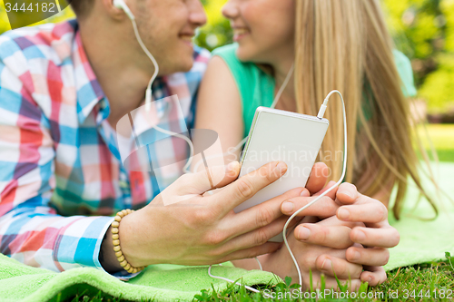 Image of close up of couple with smartphone and earphones