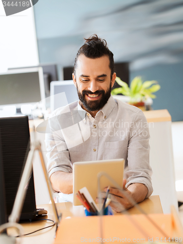 Image of happy creative male office worker with tablet pc