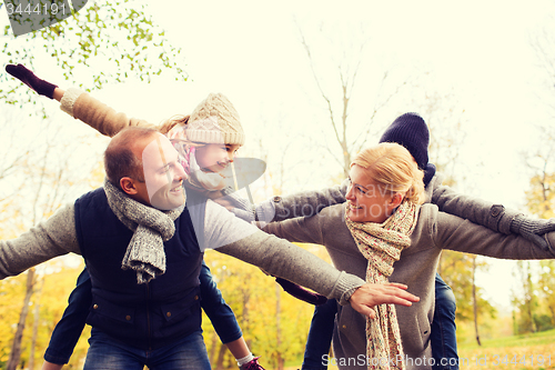 Image of happy family having fun in autumn park