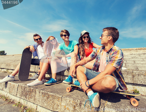 Image of group of smiling friends sitting on city street