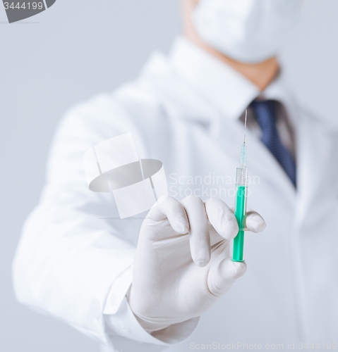 Image of male doctor holding syringe with injection