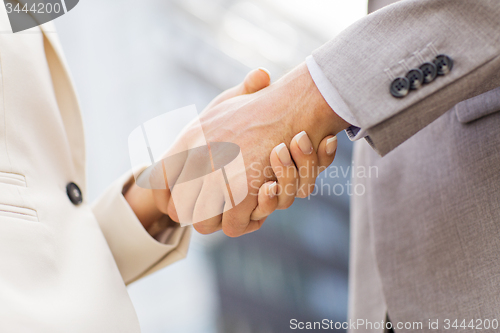 Image of close up of business couple shaking hands