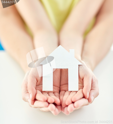 Image of close up of woman and girl hands with paper house