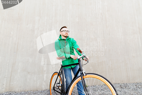 Image of happy young hipster man with fixed gear bike