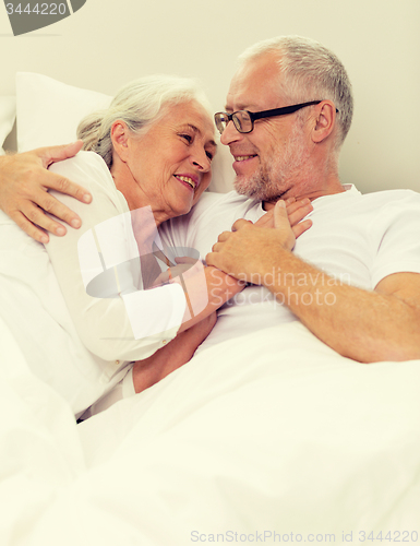 Image of happy senior coupler lying in bad at home