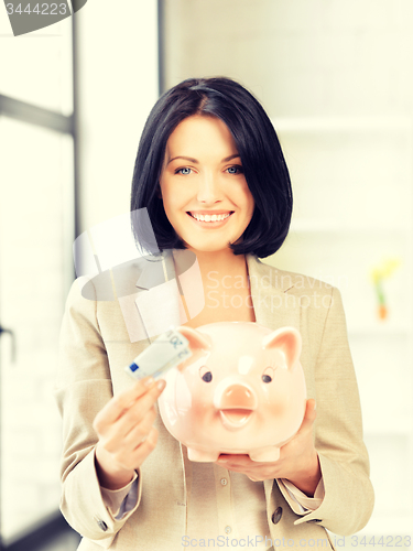 Image of lovely woman with piggy bank and money