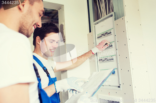 Image of builders with clipboard and electrical panel