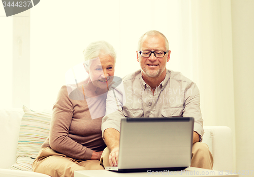 Image of happy senior couple with laptop at home