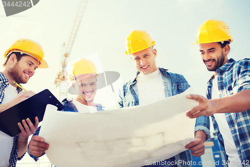 Image of group of builders with tablet pc and blueprint