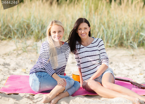 Image of happy teenage girls or young women on beach