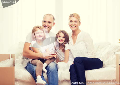 Image of smiling parents and two little girls at new home