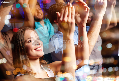 Image of smiling friends at concert in club