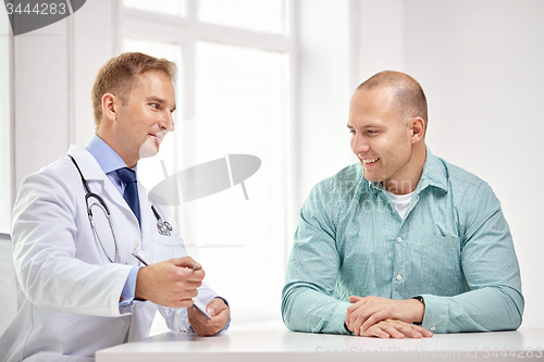 Image of male doctor and patient with clipboard at hospital