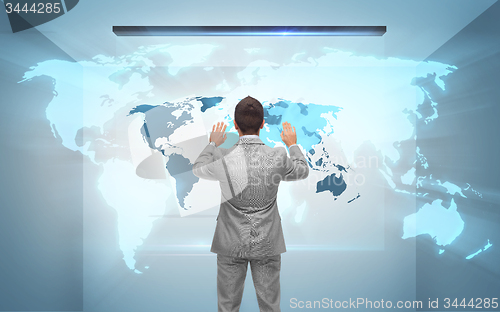 Image of businessman working with hologram of world map