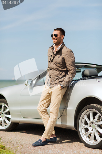 Image of happy man near cabriolet car outdoors