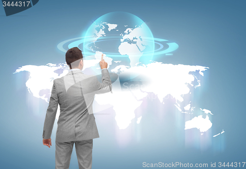 Image of businessman pointing finger to globe projection