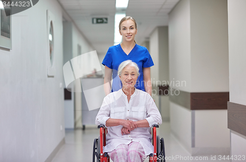 Image of nurse with senior woman in wheelchair at hospital