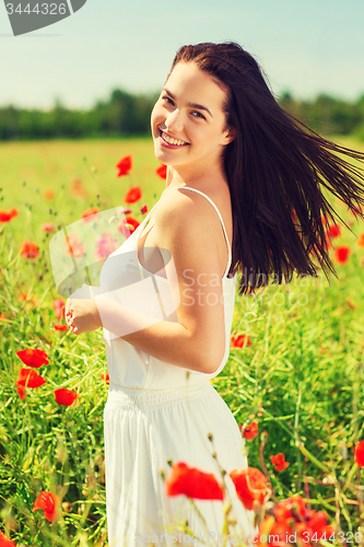 Image of smiling young woman on poppy field