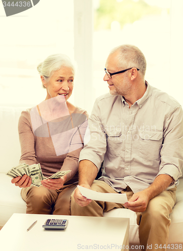 Image of senior couple with money and calculator at home