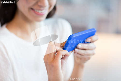 Image of close up of woman with smartphone at cafe