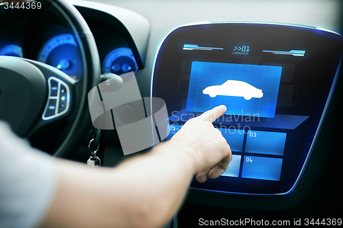 Image of male hand pointing finger to car icon on panel