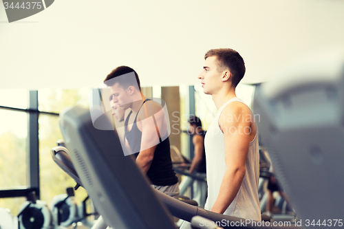 Image of group of men exercising on treadmill in gym