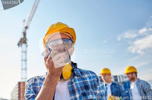 Image of builder in hardhat with walkie talkie