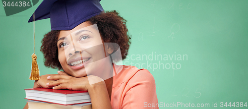 Image of happy african bachelor girl with books at school