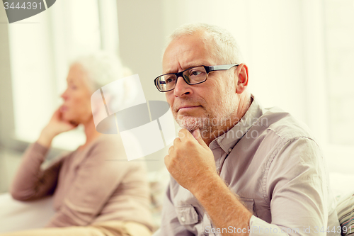 Image of senior couple sitting on sofa at home