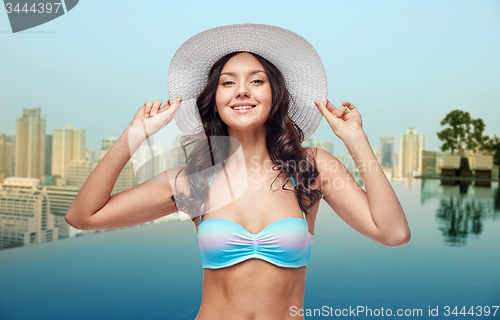 Image of happy young woman in bikini swimsuit and sun hat