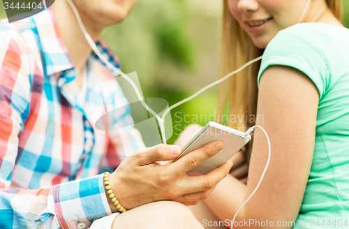 Image of close up of couple with smartphone and earphones