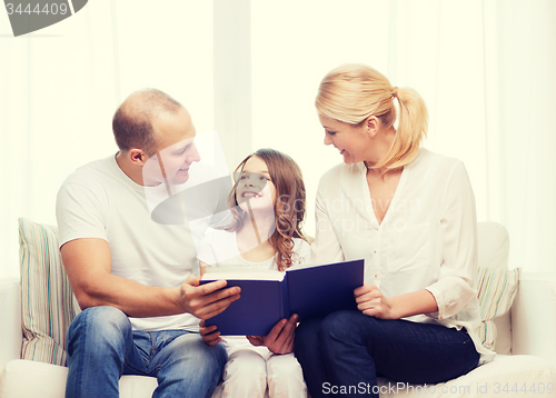 Image of smiling parents and little girl with at home