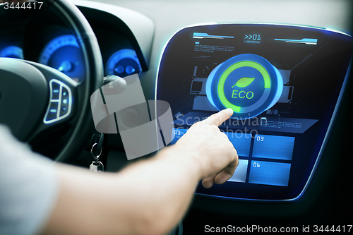 Image of male hand setting car eco system mode on screen
